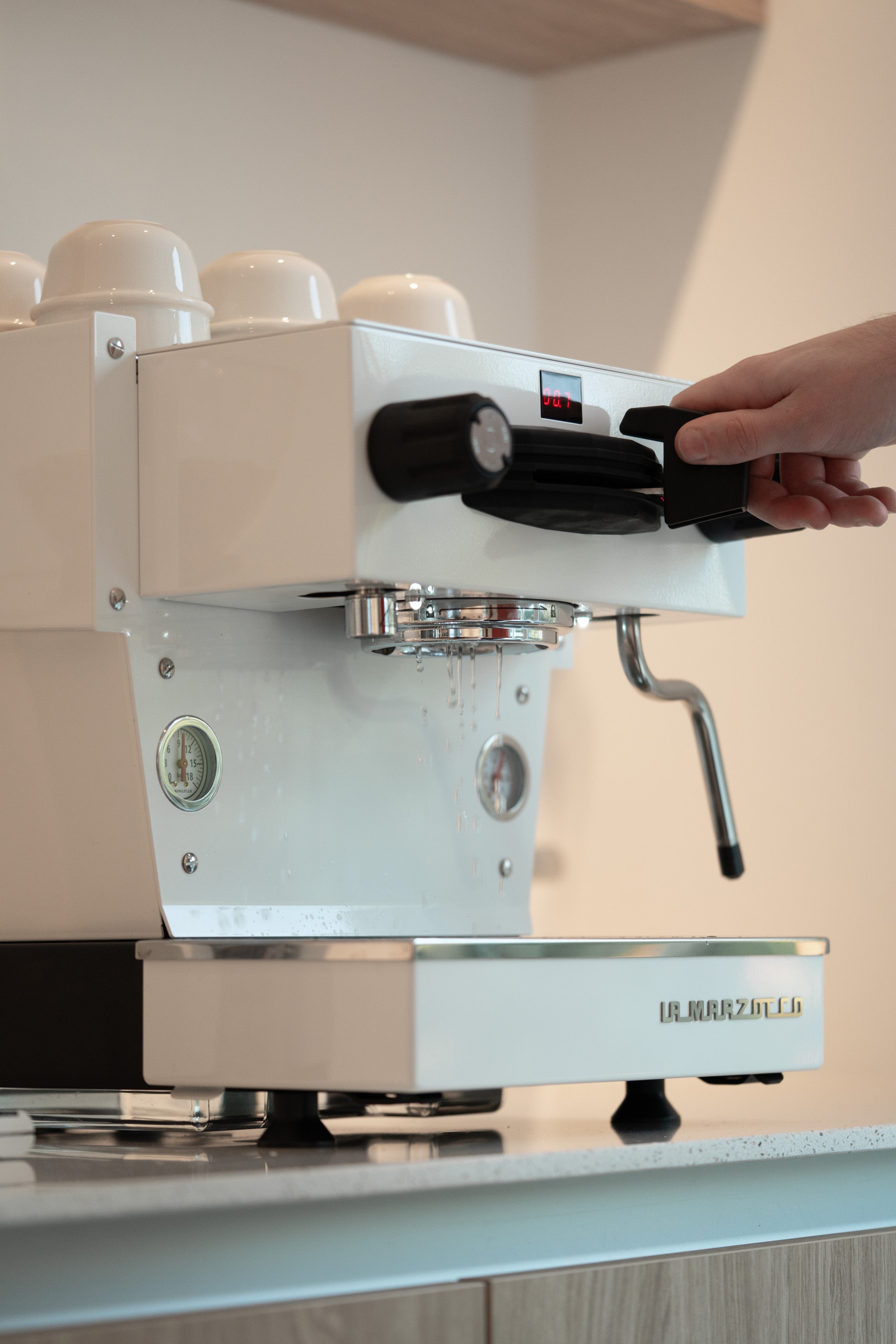La Marzocco espresso machine die aanstaat en waar water doorloopt zonder filterdrager.